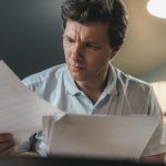 Imigrante brasileiro revisando documentos sobre nacionalidade portuguesa por tempo de residência